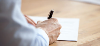 person writing a letter over a desk