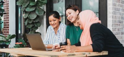 Three women looking at a laptop together