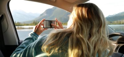 woman looking out car window to lake