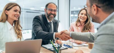 professionals shaking hands in a table