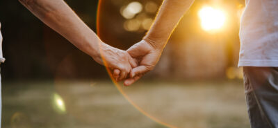a Couple holding hands, walking towards the sunset. The image symbolizes the journey of love and togetherness in spousal sponsorship, as couples embark on a new chapter in Canada.