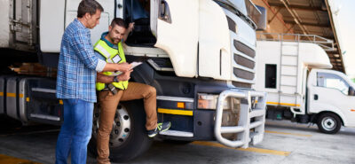 two transport professionals in front of a truck