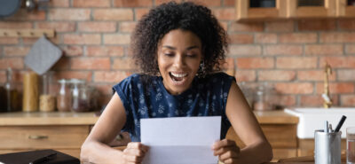 happy woman opening an envelope with an invitation