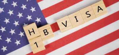An USA flag with the letters H1B visa over